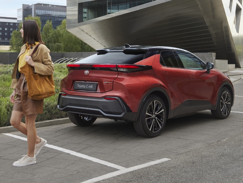 Žluté Toyota Yaris Cross Hybrid jedoucí po městské ulici.